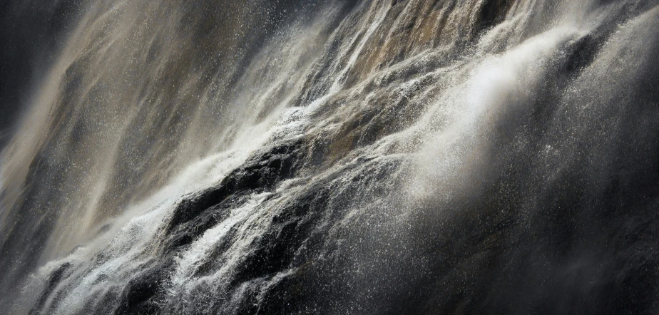 water gushing from a waterfall as it rains down