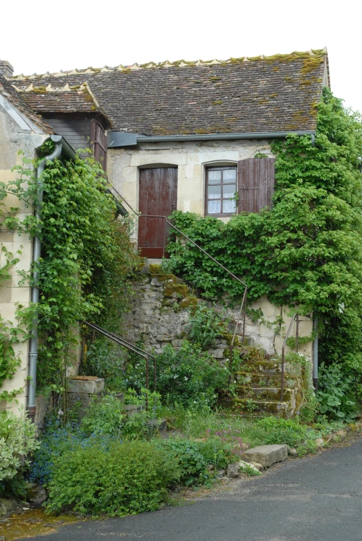 an abandoned building with ivy growing over the top