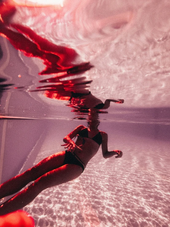 a person with long legs in the water with red colors