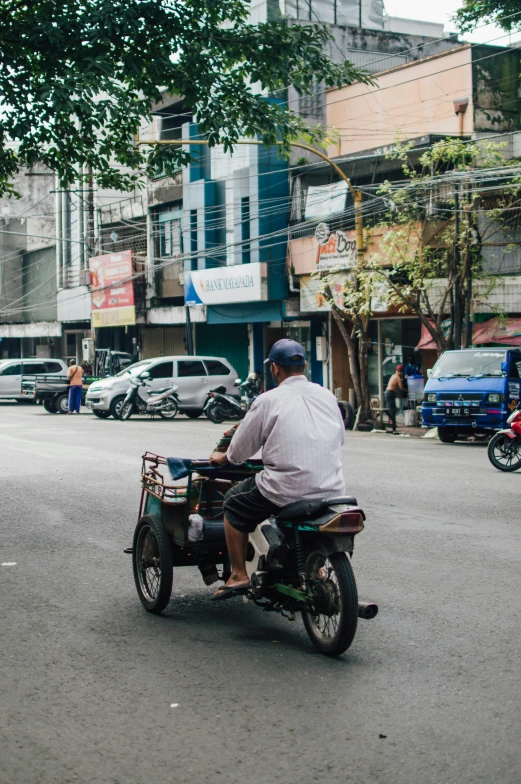 a man riding a motorcycle in the middle of an urban street