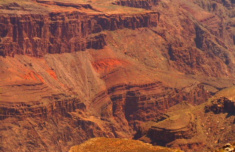 a very high and dark looking canyon with orange rocks