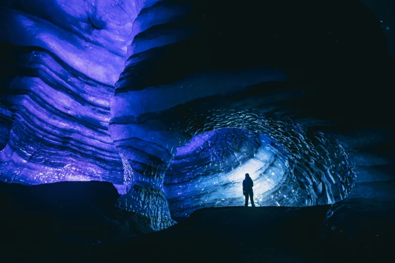 a man standing in a dark tunnel with blue lighting