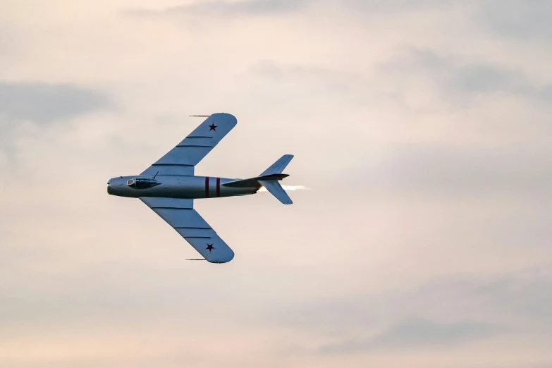 an old airplane in flight on a cloudy day