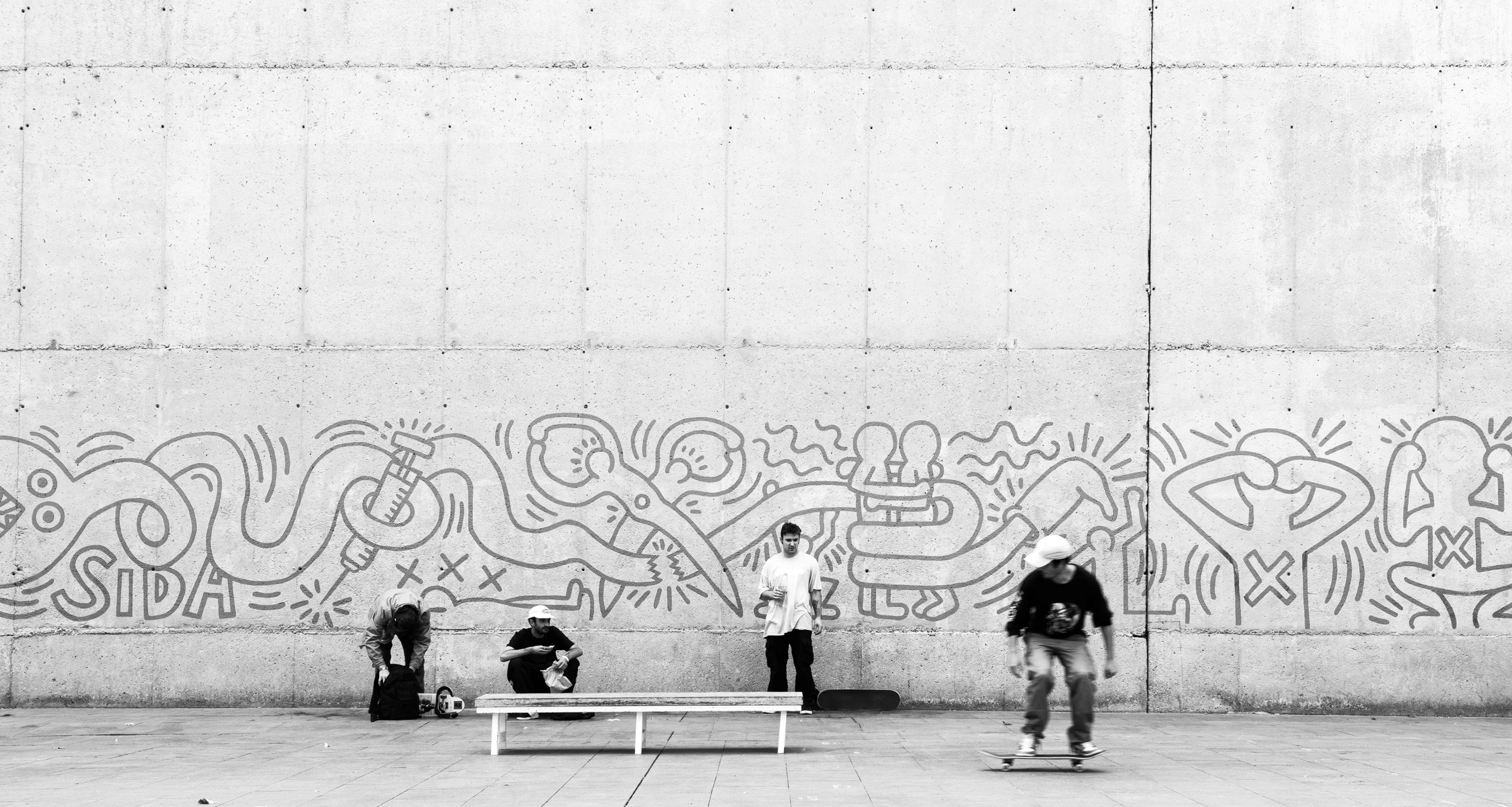 some people sitting on a bench with graffiti