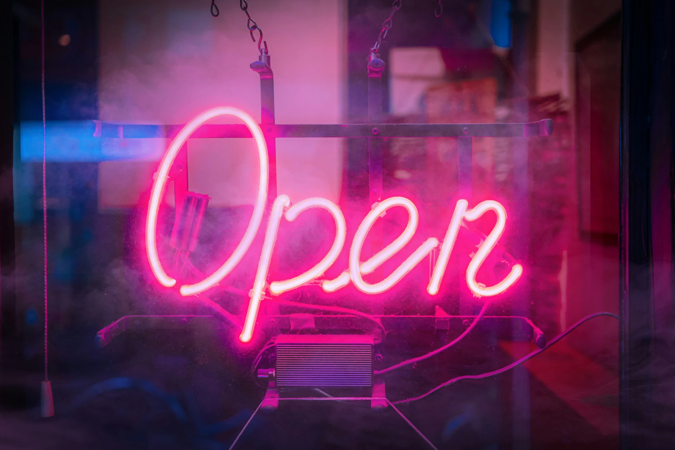 a neon open sign is hung in a room