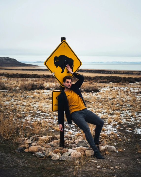 a man posing in front of a bear crossing sign