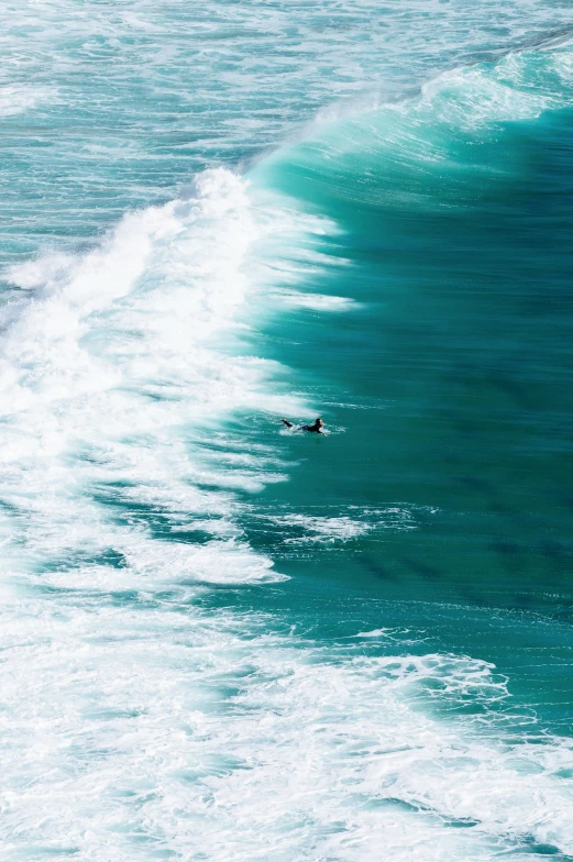 a person surfing on the ocean waves near the beach