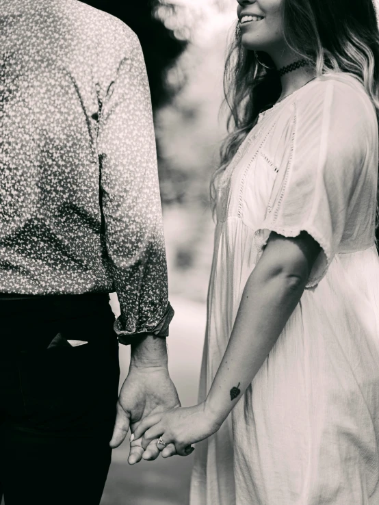 a man and woman standing in front of each other holding hands