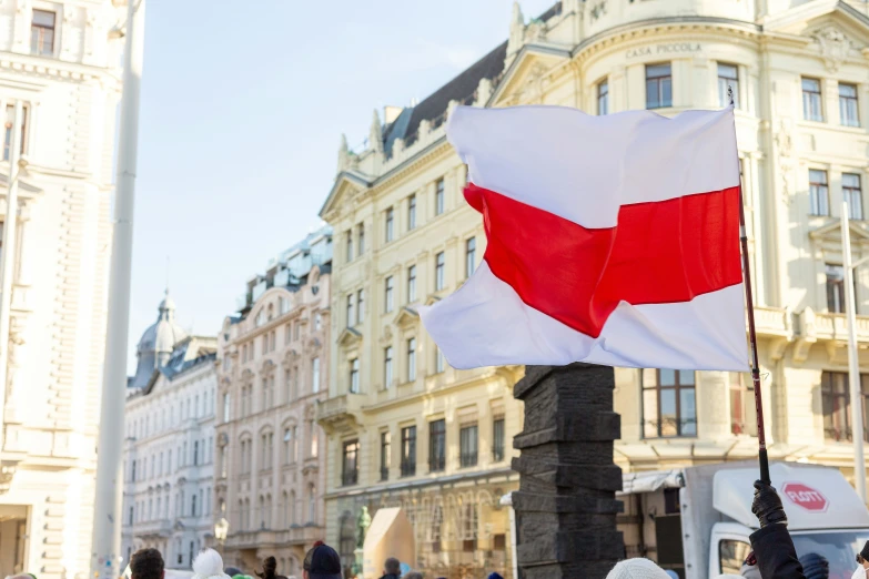 the flag is in front of a building with many people