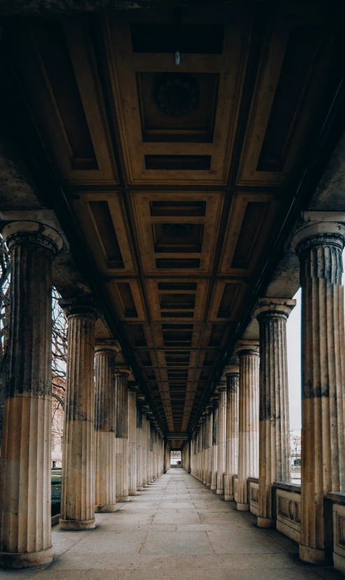 the walkway is lined with stone pillars and columns