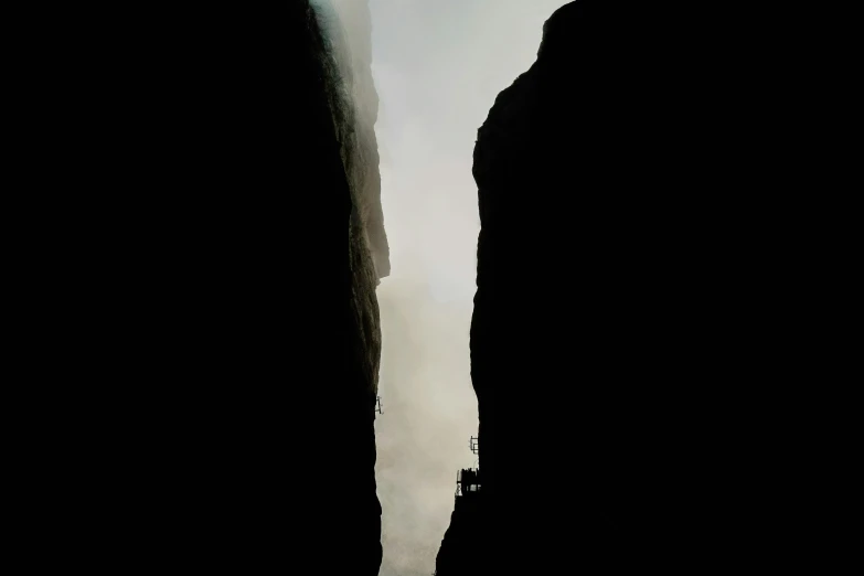 the side of a cliff with mountains in the distance