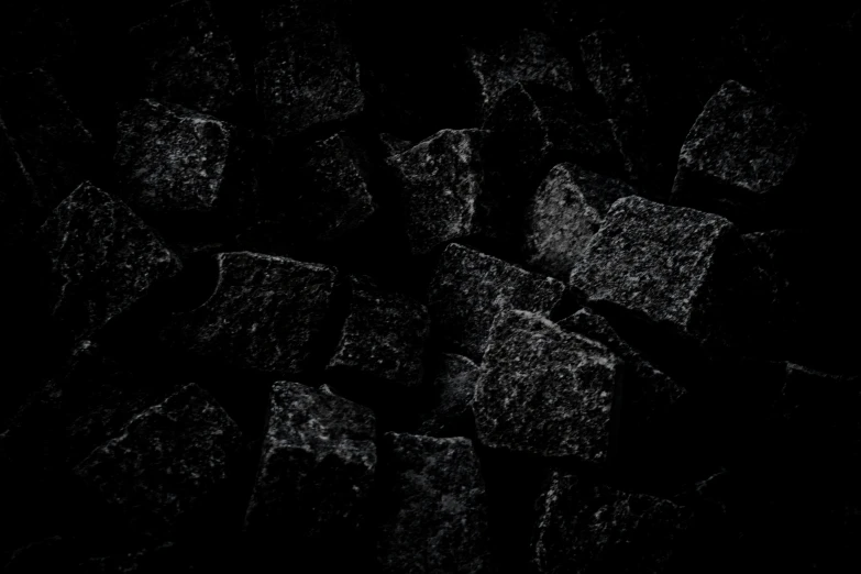 several pieces of dark colored rocks on a black background