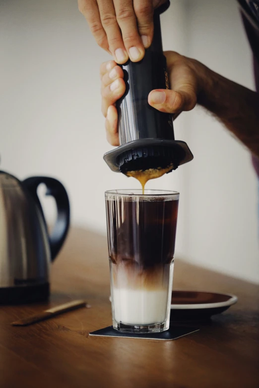 someone is pouring coffee into a glass with ice cream