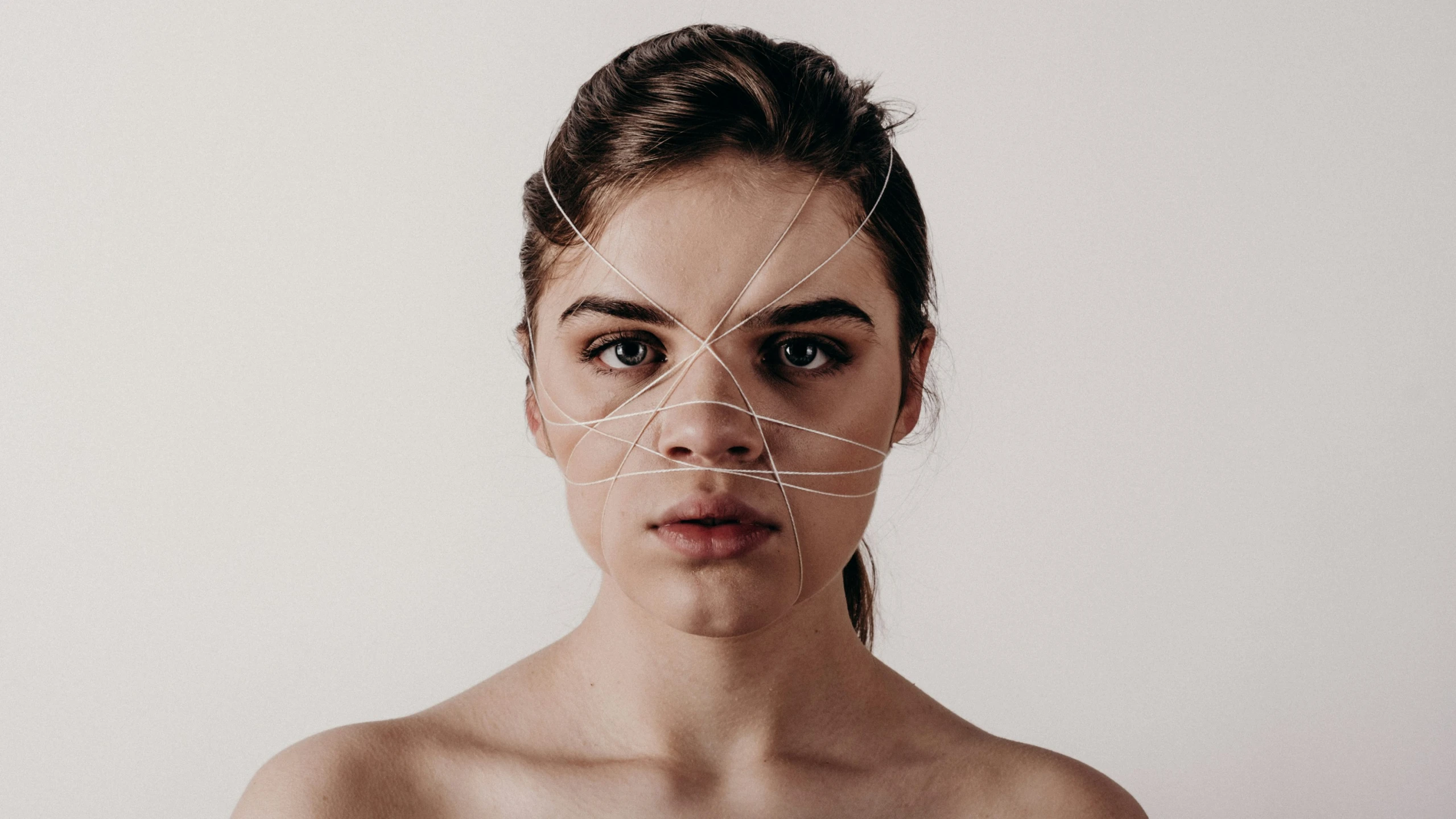 a beautiful young woman making faces with white strips on her face