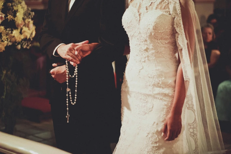 a man and woman dressed in wedding clothes holding hands