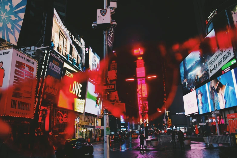 several lit up neon signs over a city street