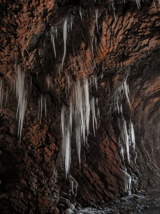 the water looks like ice hanging off of the side of a cliff