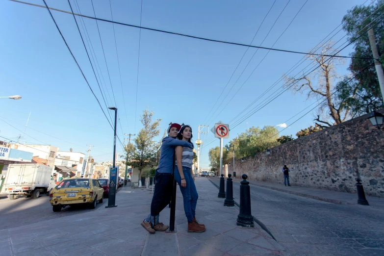 two people are standing outside near a street