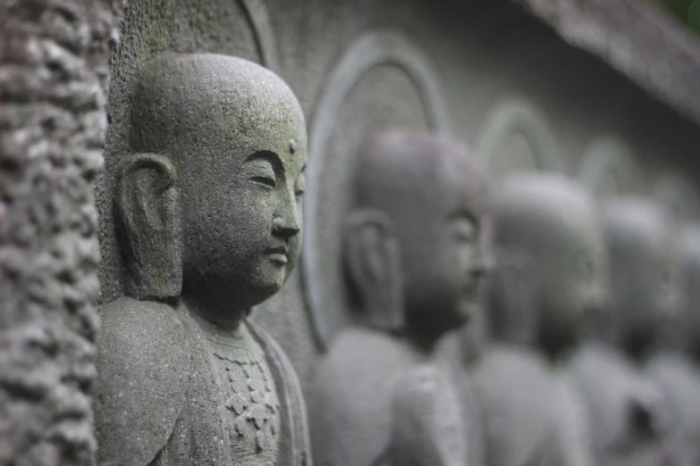 rows of buddha statues in front of large heads