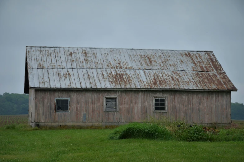 an old shed sitting on a green grass field