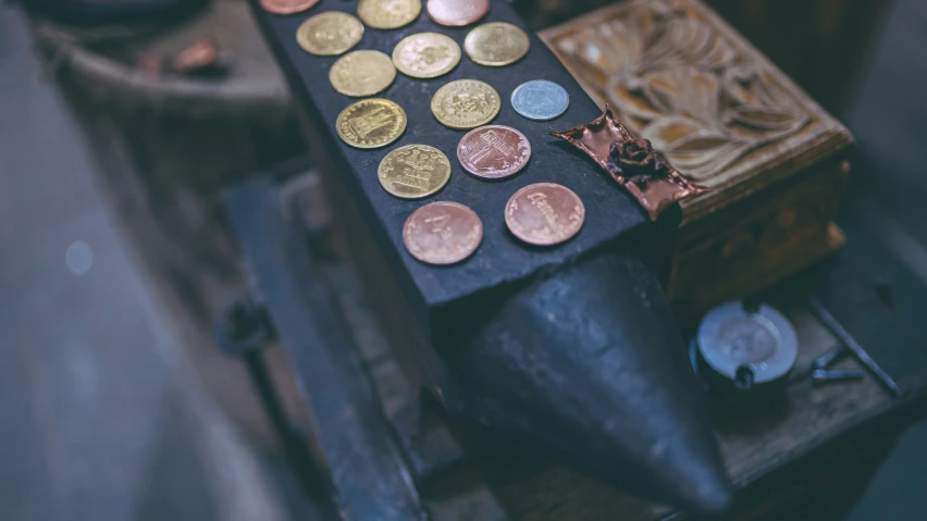 some gold coins laying on a workbench