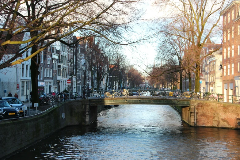 view of a canal between brick buildings and parked bicycles
