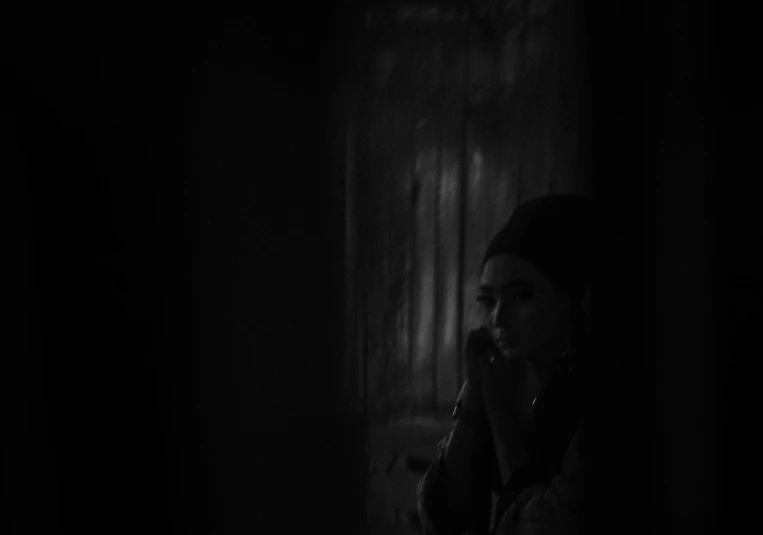 a woman talks on a cell phone in the dark