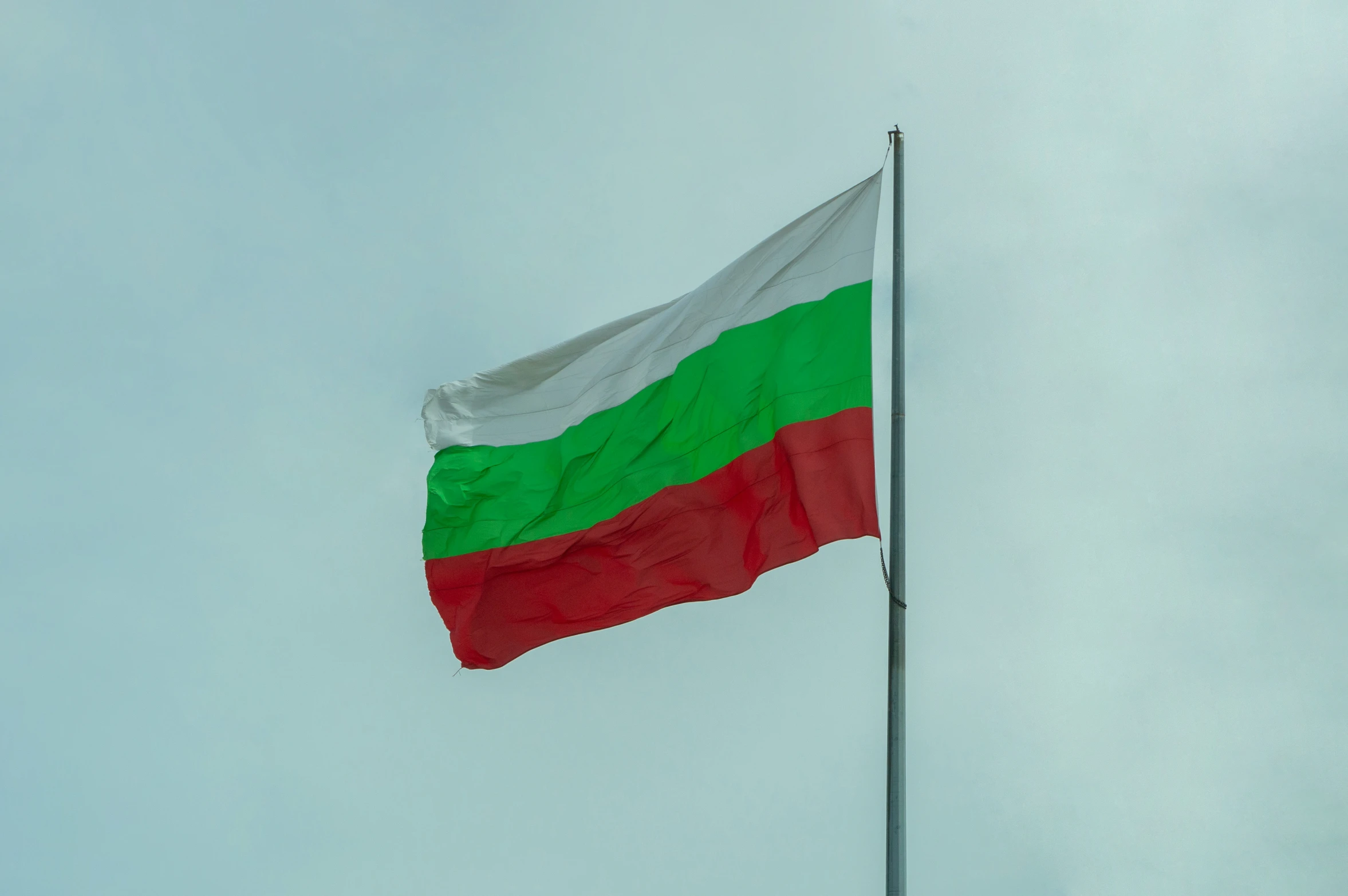 a flag flying in the sky above a pole