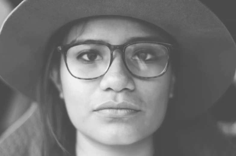 black and white pograph of a woman wearing glasses and hat