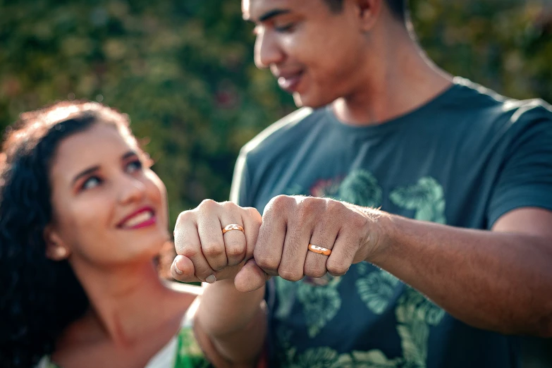 a man and woman standing close together with their hands