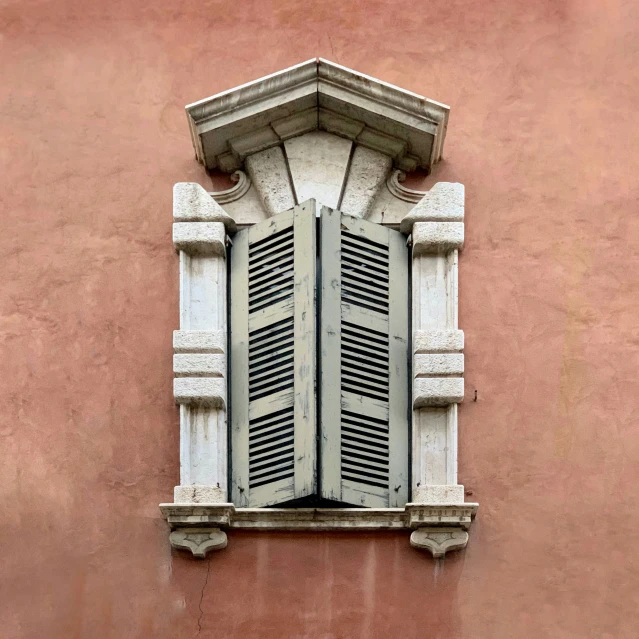 there is an old fashioned window with shutters and no curtain