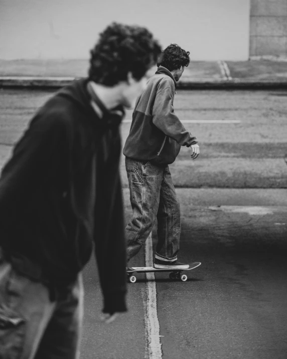 two people are skating down the street together