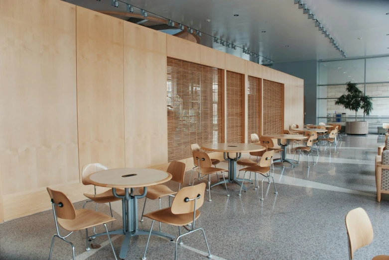 rows of tables with chairs around them with wooden partitions on both sides