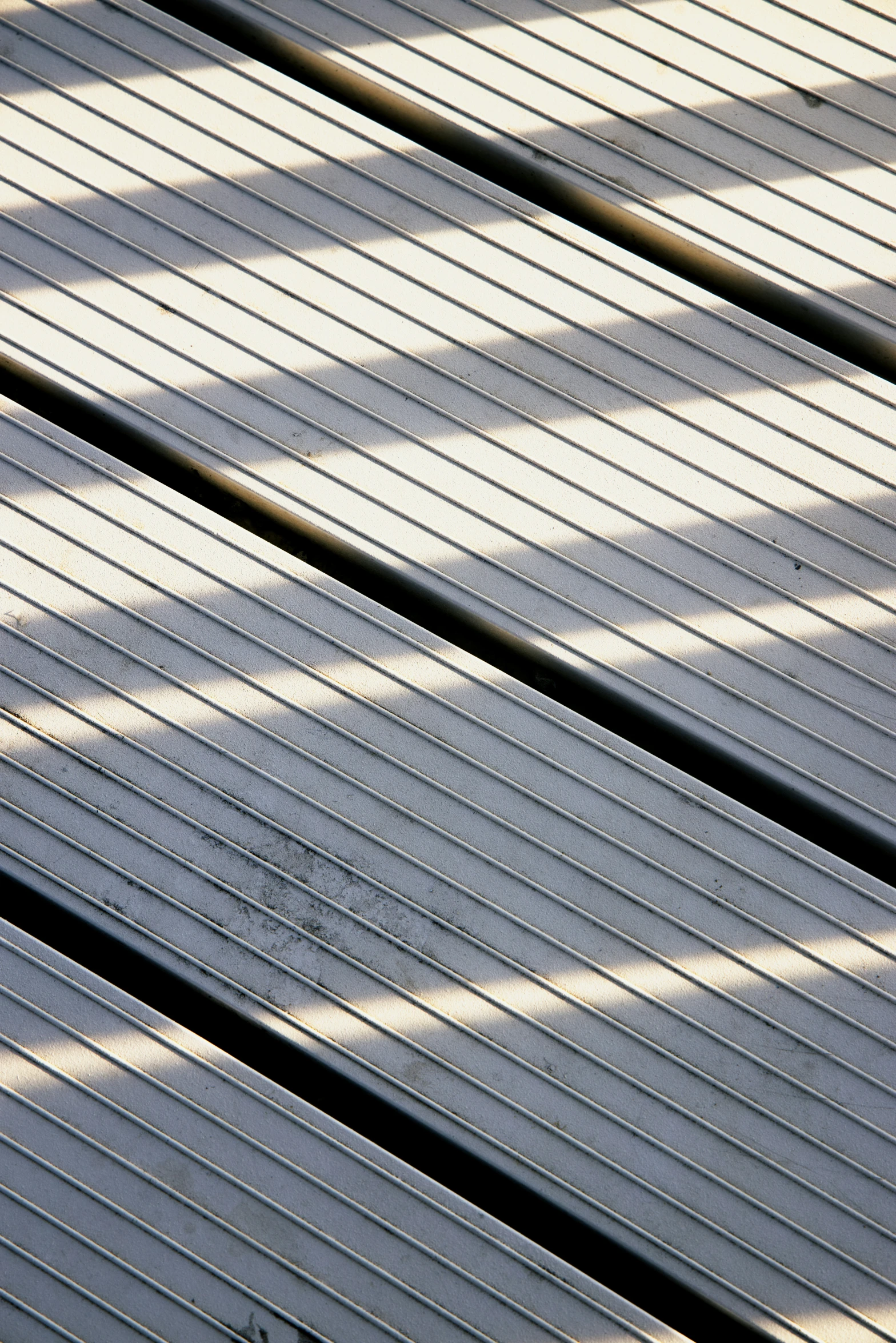 a bird sitting on the side of a white bench