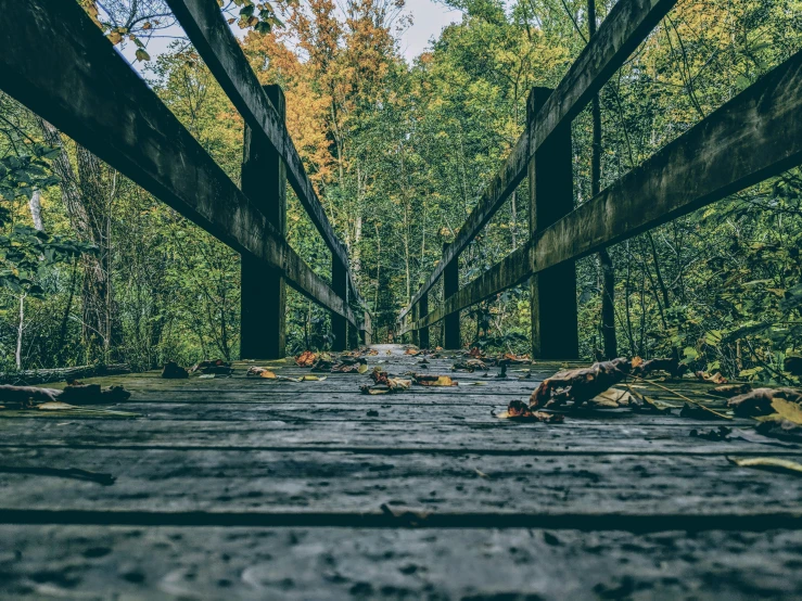 an old abandoned bridge with wooden planks in the middle