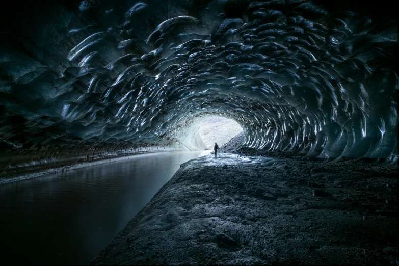 a person standing inside of a very large tunnel