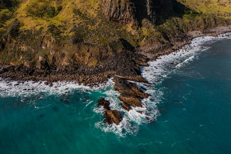 an aerial view of an ocean and cliffs