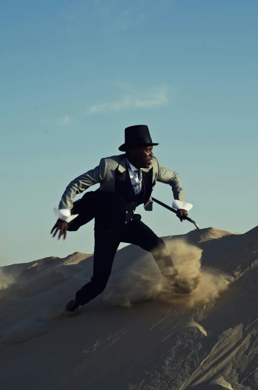 man in top hat standing on top of the sand