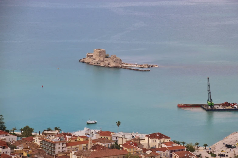 this is the sea, with two large boats and an island in the background