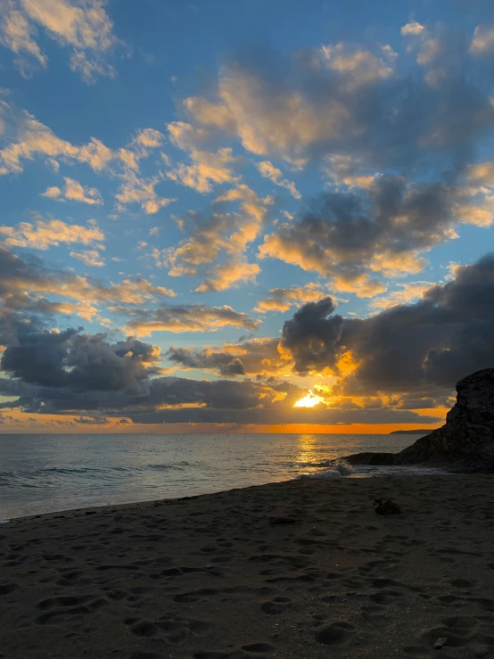 sunset with clouds and a surfboard in foreground