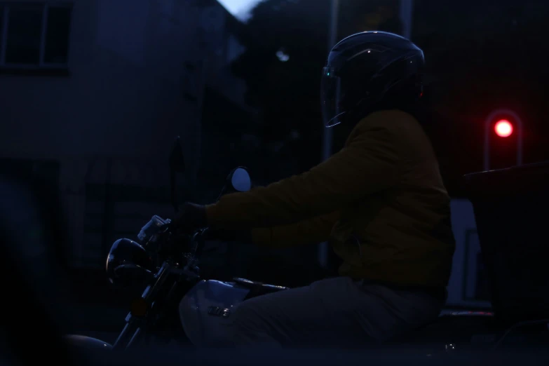 a person wearing a helmet and goggles riding a motorcycle at night