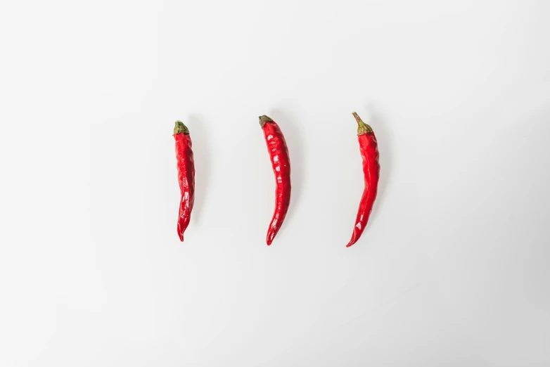 three chili peppers are shown lined up in a row