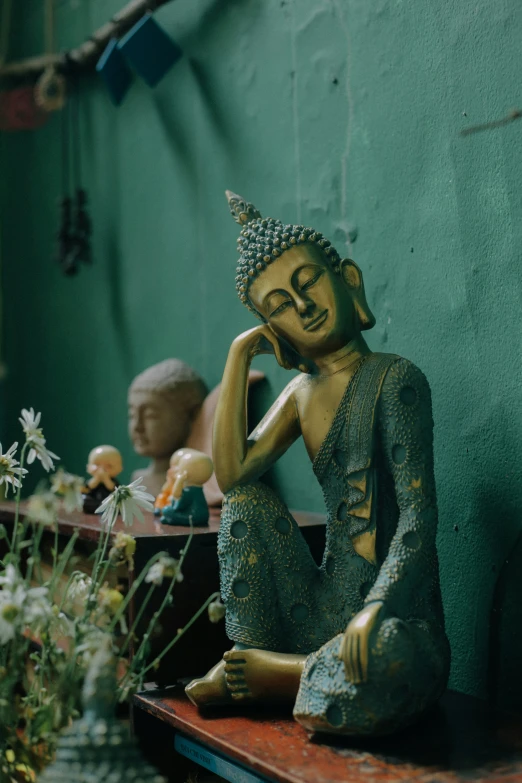 statue sitting on a table next to a green wall