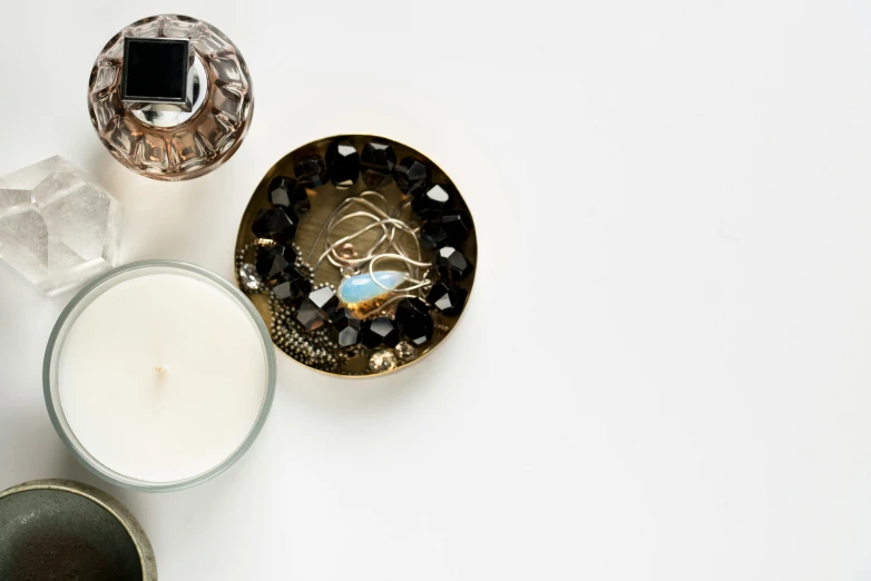 two candles sitting next to each other in front of some crystal dishes