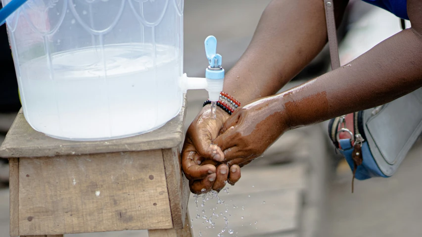 a person is getting their water to drink from a water bottle