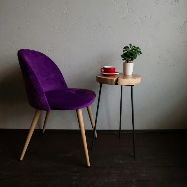 a table with a potted plant next to a purple chair