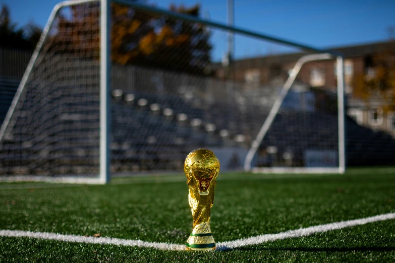 a golden cup is on the edge of a soccer field