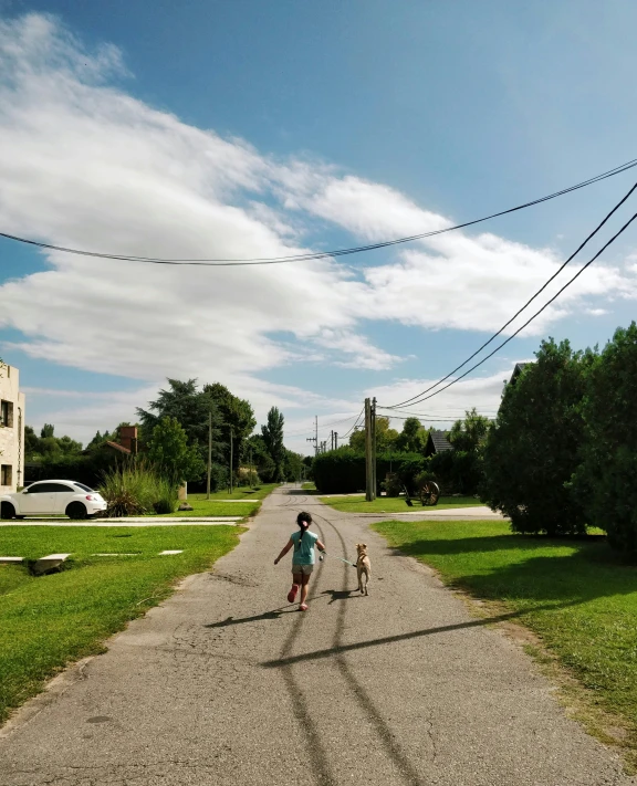 a little boy walking down a road with his dog