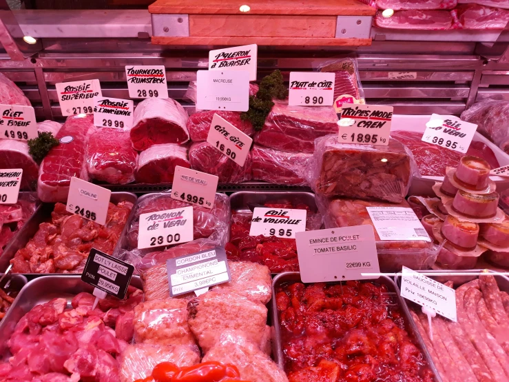 meat displayed for sale in bins at a butchers