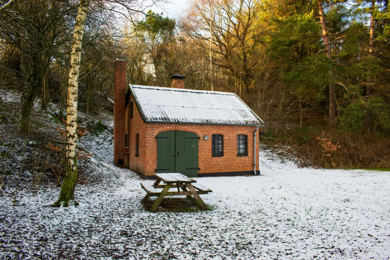 there is a small red brick building in the snow